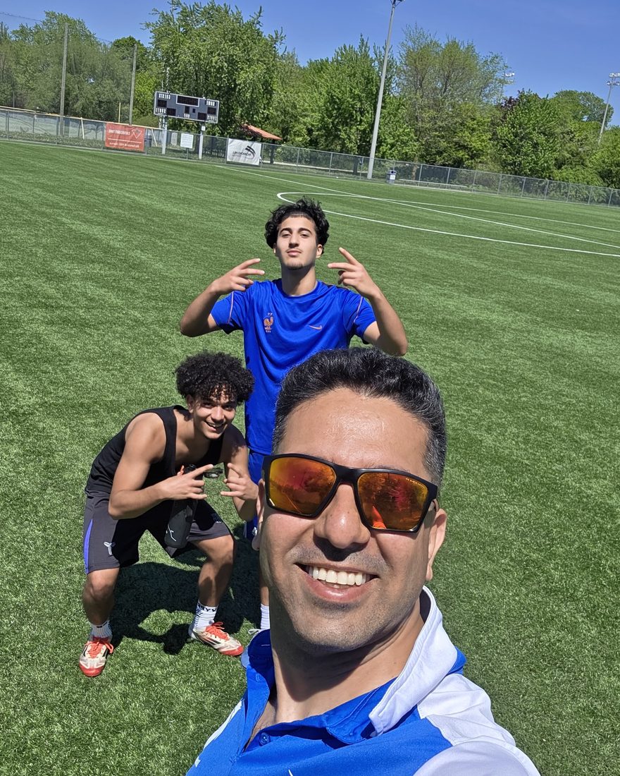 Coach Reza with players on the field